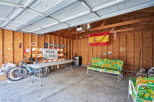 garage featuring wood walls and a garage door opener