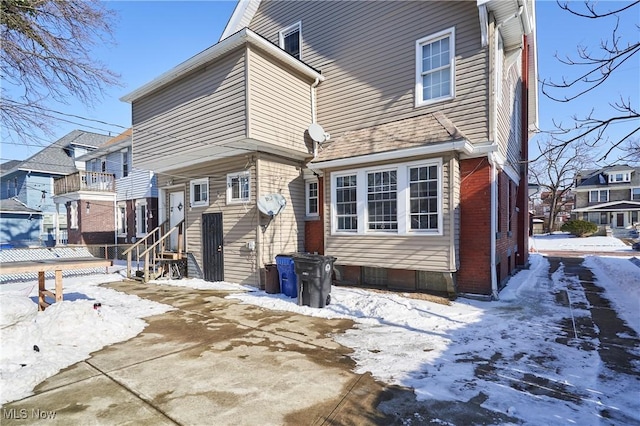 view of snow covered rear of property