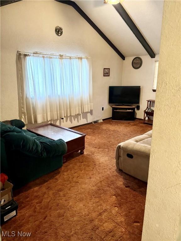 carpeted living room with high vaulted ceiling and beamed ceiling