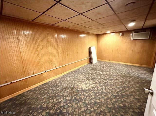 basement featuring carpet flooring and wood walls