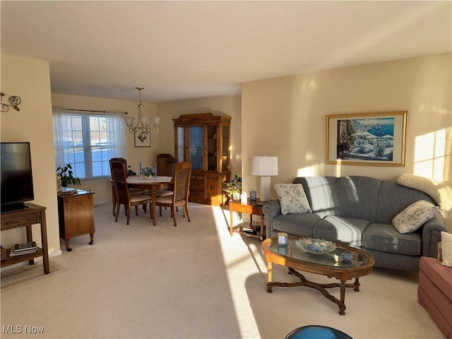 carpeted living room with a chandelier