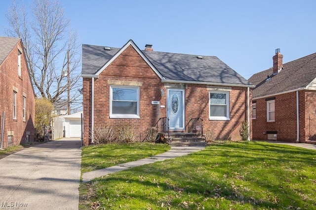 bungalow with a front lawn, a garage, and an outbuilding