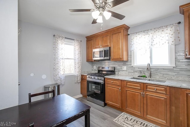 kitchen featuring light stone countertops, sink, stainless steel appliances, and tasteful backsplash