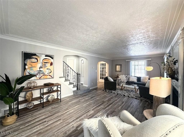 living room with a textured ceiling, crown molding, and wood-type flooring