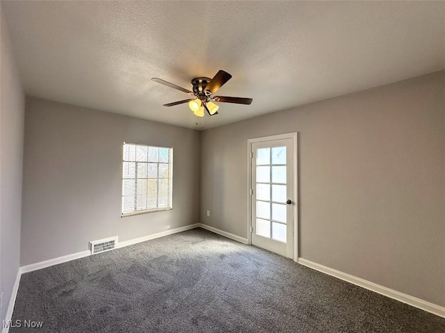 spare room featuring carpet floors, a textured ceiling, ceiling fan, and a healthy amount of sunlight