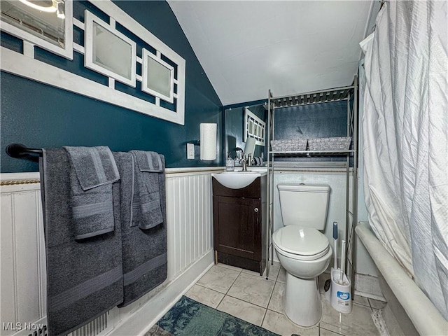 full bathroom featuring lofted ceiling, shower / bathtub combination with curtain, tile patterned flooring, vanity, and toilet