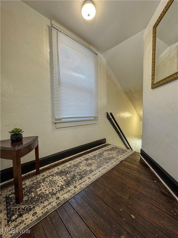 staircase featuring lofted ceiling and hardwood / wood-style flooring