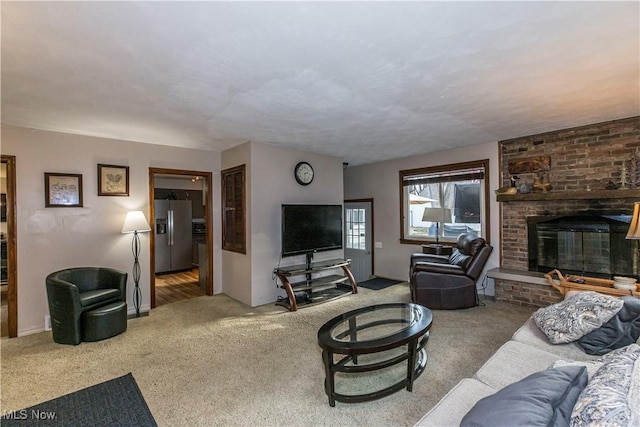 carpeted living room featuring a brick fireplace and a textured ceiling