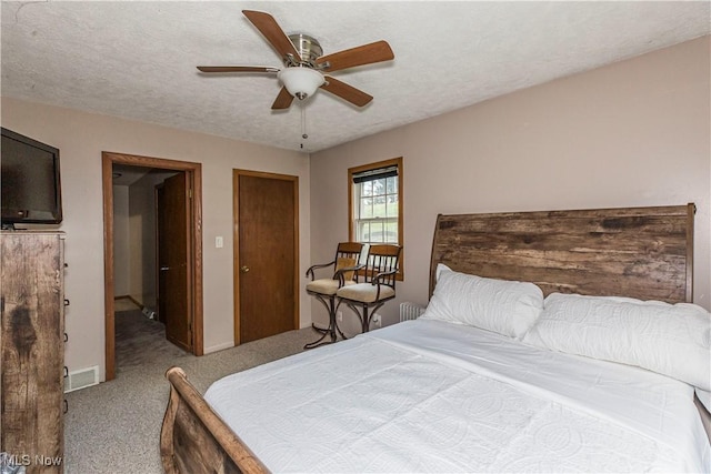 carpeted bedroom with a textured ceiling and ceiling fan