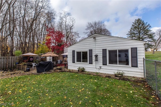 back of house with central AC and a yard