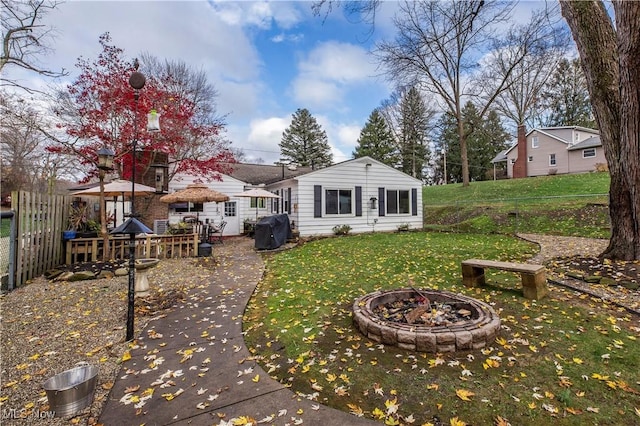 back of house featuring a gazebo, a yard, and a fire pit