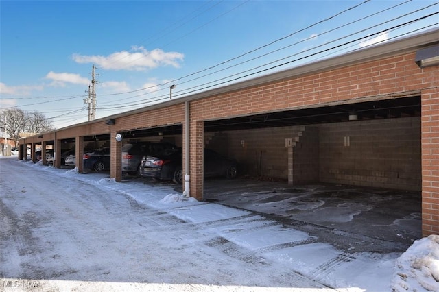 snow covered parking area with a carport