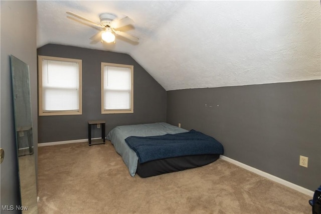 carpeted bedroom with ceiling fan, a textured ceiling, and lofted ceiling