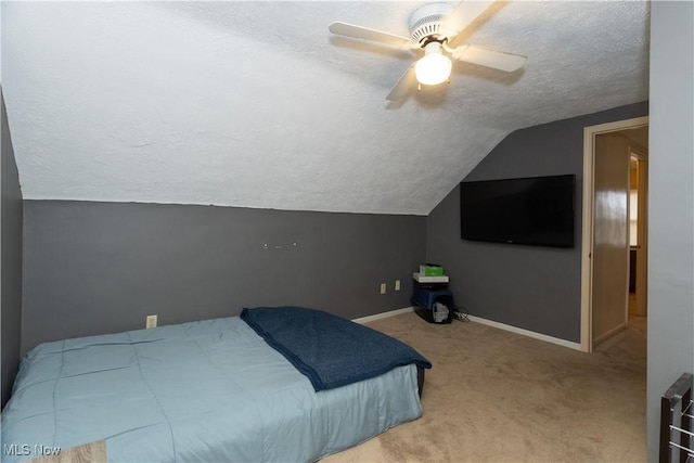 bedroom with ceiling fan, a textured ceiling, light carpet, and lofted ceiling