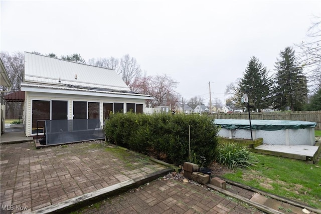 view of patio / terrace with a sunroom and a covered pool