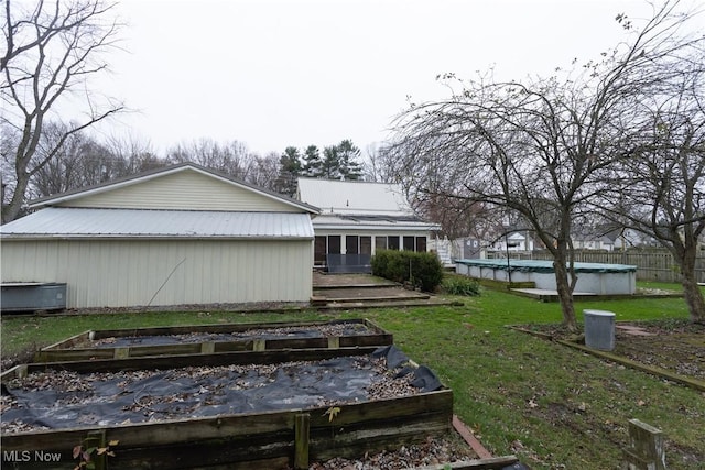 view of property exterior featuring a lawn and a covered pool