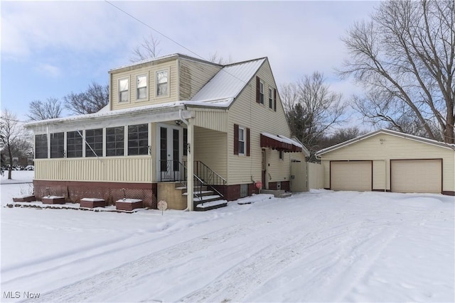 view of front of home with a garage and an outbuilding