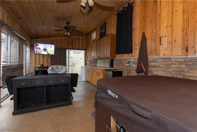 interior space featuring ceiling fan, wooden walls, wood ceiling, and vaulted ceiling