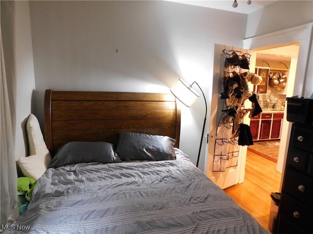 bedroom featuring wood-type flooring and sink