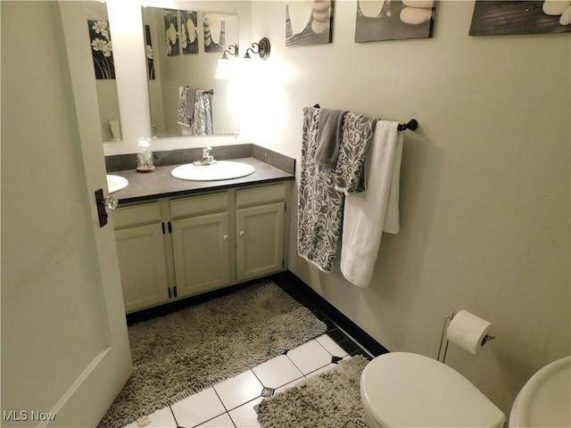 bathroom with toilet, tile patterned flooring, and vanity