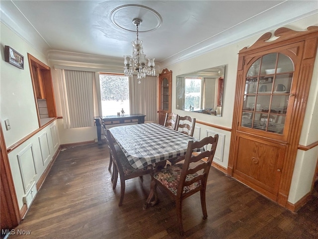 dining room with crown molding, dark hardwood / wood-style flooring, and an inviting chandelier