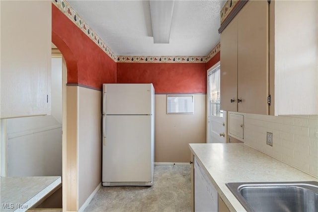 kitchen featuring backsplash and white appliances