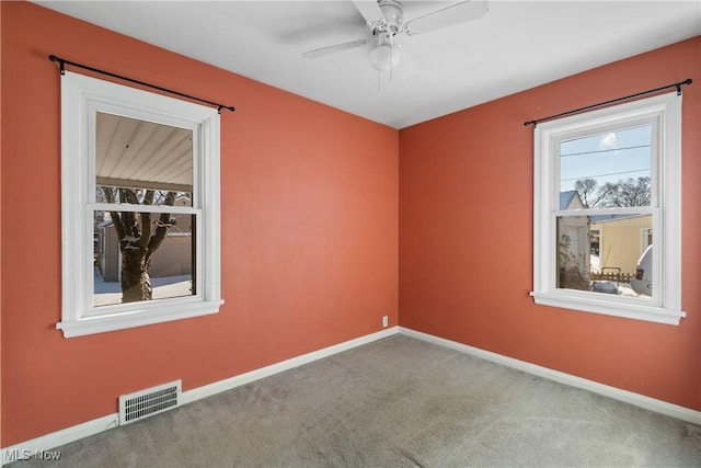 carpeted spare room featuring ceiling fan