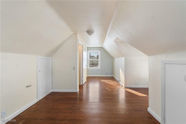 bonus room with vaulted ceiling and dark wood-type flooring