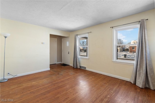 unfurnished room featuring a textured ceiling and wood-type flooring