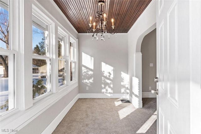 interior space featuring carpet floors, plenty of natural light, crown molding, and wooden ceiling