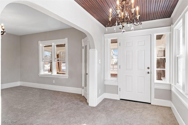 entryway with a notable chandelier, light carpet, and wood ceiling