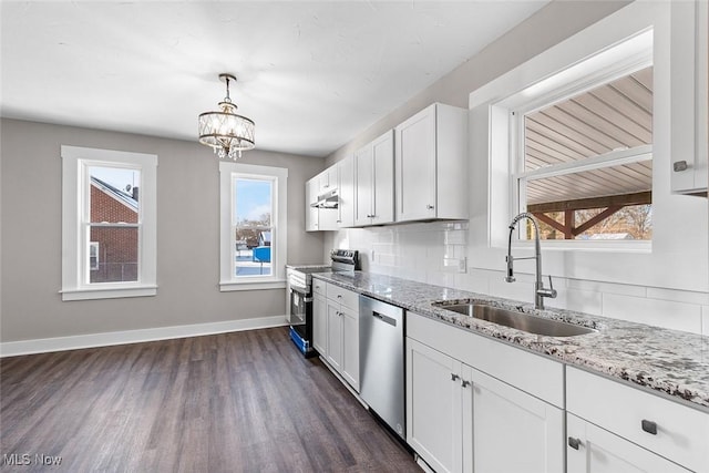 kitchen with white cabinets, appliances with stainless steel finishes, decorative light fixtures, tasteful backsplash, and sink