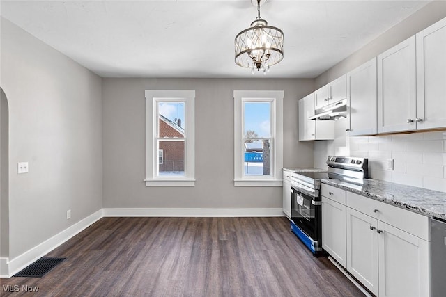 kitchen featuring stainless steel range with electric stovetop, backsplash, white cabinets, hanging light fixtures, and light stone counters