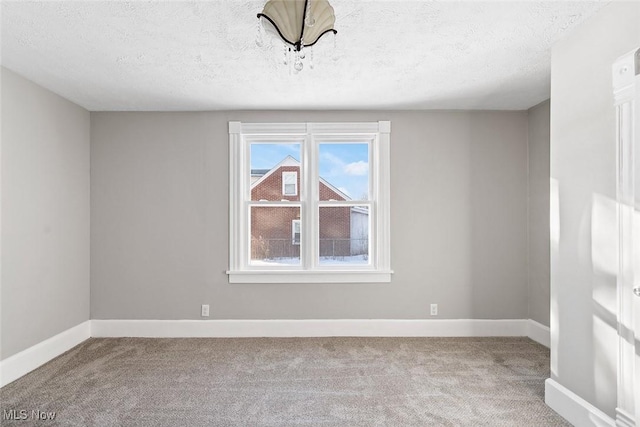 unfurnished room with carpet and a textured ceiling