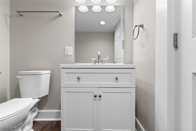 bathroom featuring toilet, hardwood / wood-style floors, and vanity