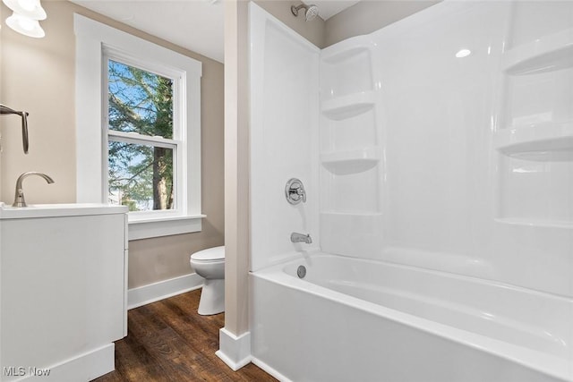 full bathroom featuring hardwood / wood-style flooring, toilet, shower / washtub combination, and a healthy amount of sunlight