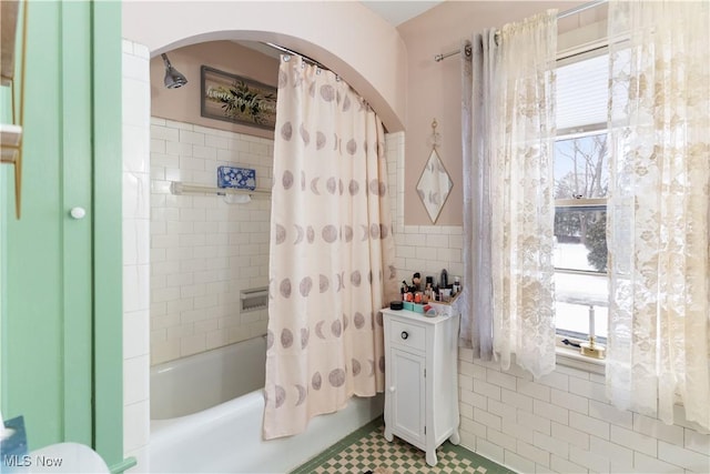 bathroom featuring tile walls and shower / bath combo