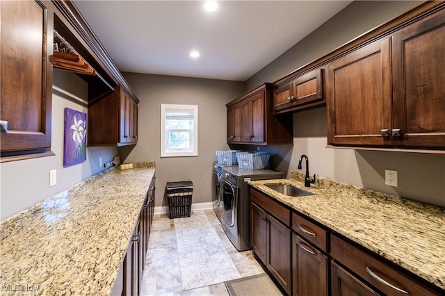 interior space with light stone countertops, sink, dark brown cabinets, and washing machine and clothes dryer