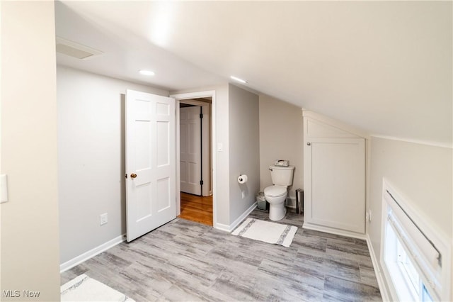 bathroom with lofted ceiling, toilet, and hardwood / wood-style floors