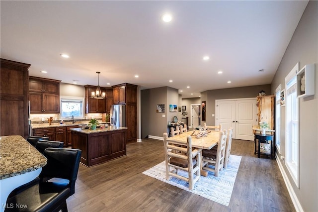 dining space with a chandelier, dark hardwood / wood-style floors, and sink