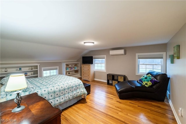 bedroom featuring an AC wall unit, wood-type flooring, and lofted ceiling