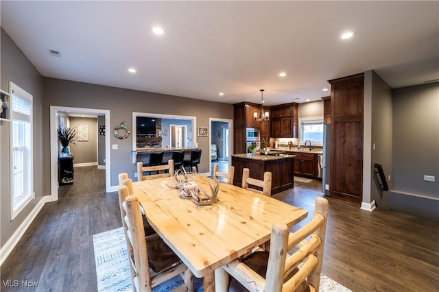 dining space with dark hardwood / wood-style floors and sink