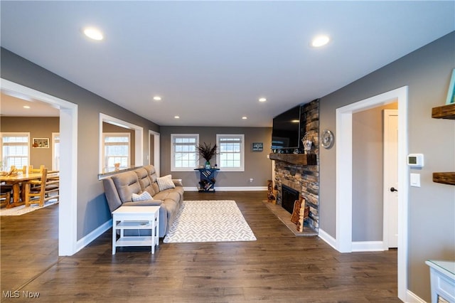 living room with a fireplace and dark wood-type flooring