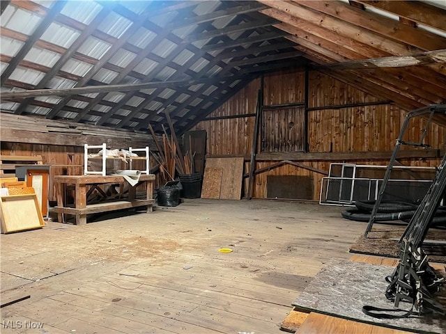 misc room with hardwood / wood-style flooring, wood walls, and vaulted ceiling