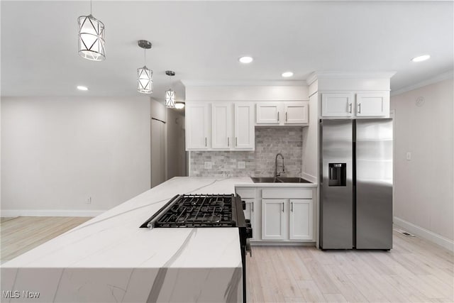 kitchen featuring decorative light fixtures, backsplash, sink, stainless steel fridge with ice dispenser, and white cabinets