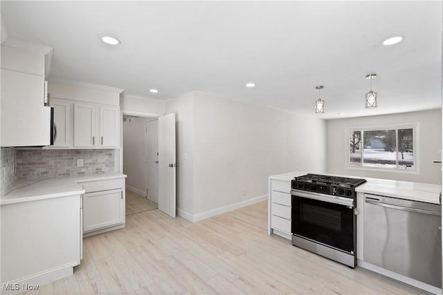 kitchen with pendant lighting, white cabinets, gas range oven, backsplash, and stainless steel dishwasher