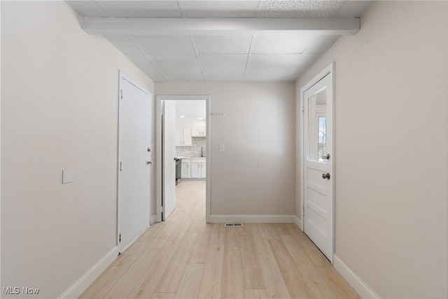 hallway featuring a drop ceiling and light hardwood / wood-style floors