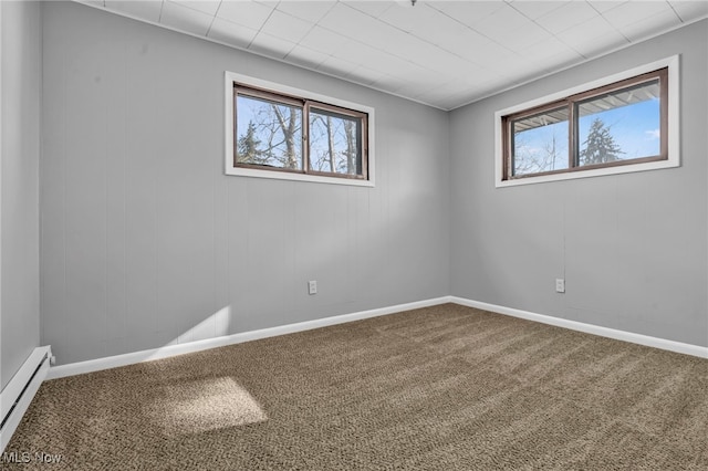 carpeted empty room with a baseboard heating unit