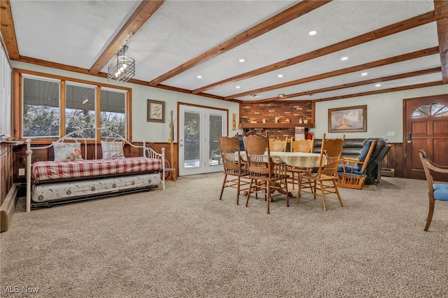 dining room with french doors, a healthy amount of sunlight, carpet floors, and beamed ceiling