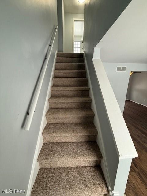 stairs featuring hardwood / wood-style flooring